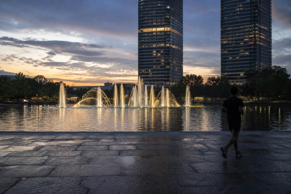 KLCC Park at dusk with fountains lit in front of the Petronas Twin Towers, no text, no logos, no people