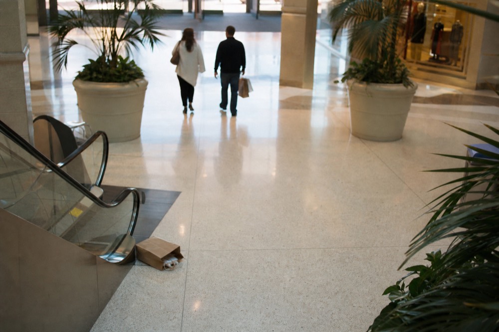 A family walking through a mall concourse toward an attraction entrance, no text, no logos, no people